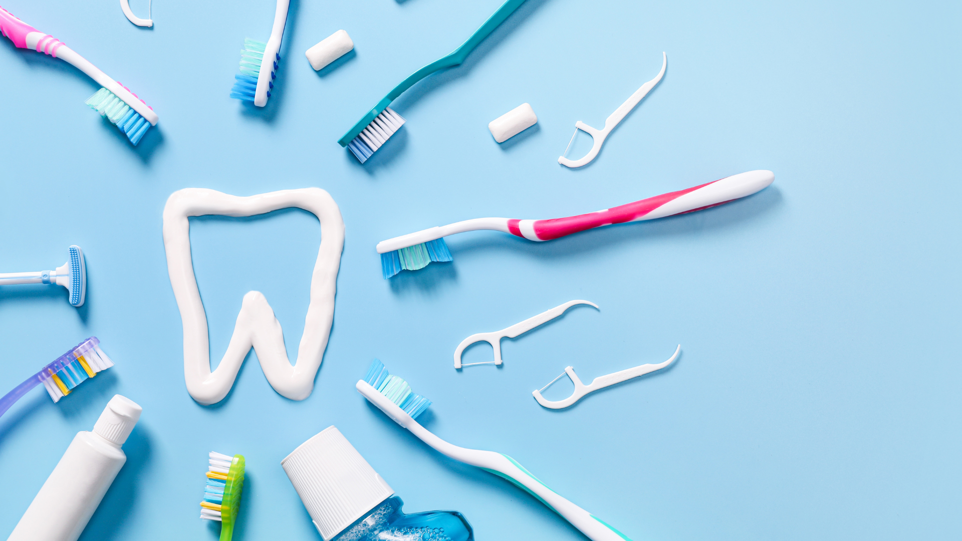Dental care items including toothbrushes, dental floss, and dental tools arranged on a light blue background